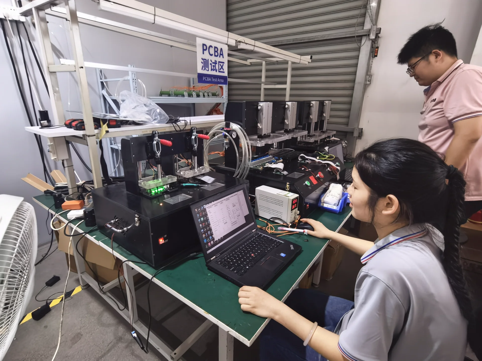 TRHT PCBA Test Area with testing equipment, a laptop, and staff conducting a test