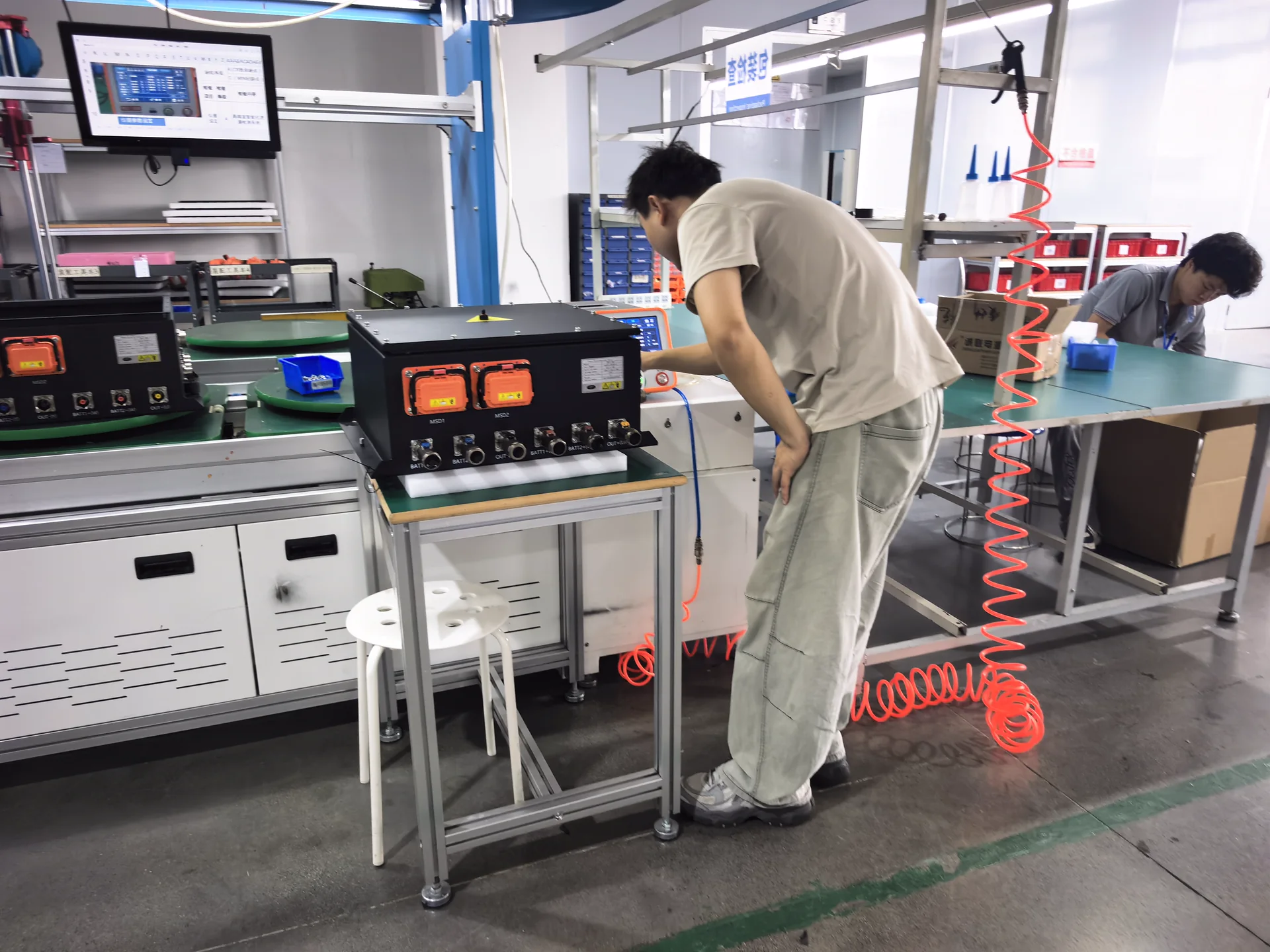 TRHT staff using test equipment to inspect wiring and electrical connections at a workbench